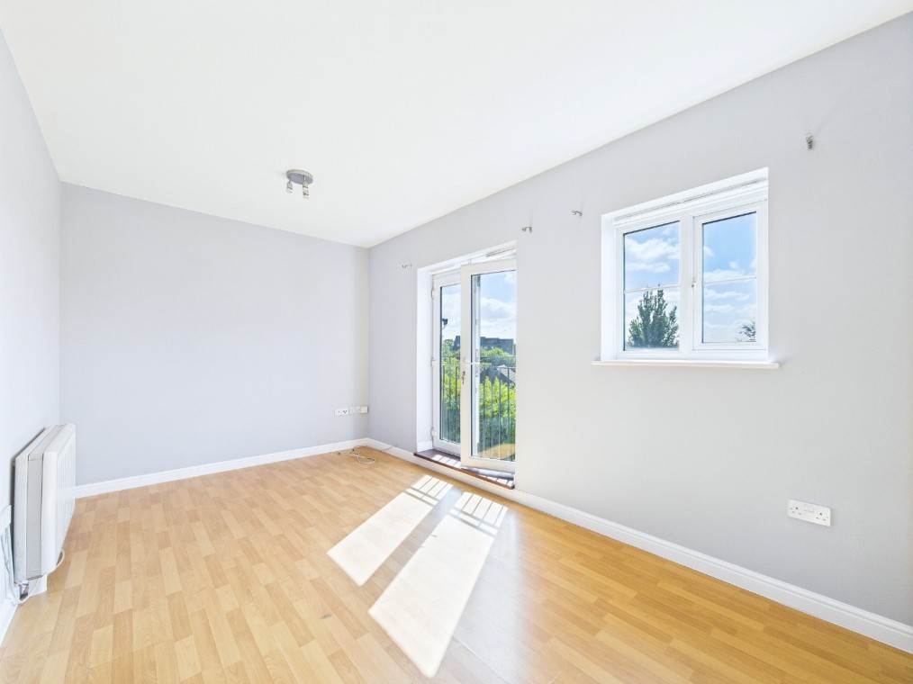 Bright and airy living room in a two-bedroom flat on Coniston Avenue, featuring large windows, wooden flooring, and access to a balcony with views.